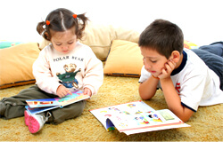 young children colouring and reading on a carpet